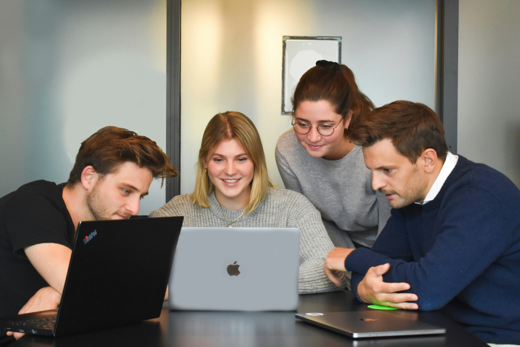 Team of professionals collaborating on laptops, representing staff augmentation