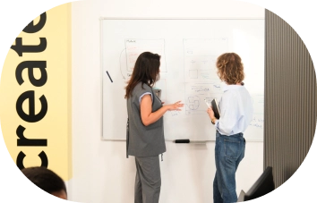 AnchorzUp's colleagues discussing the project next to the white board